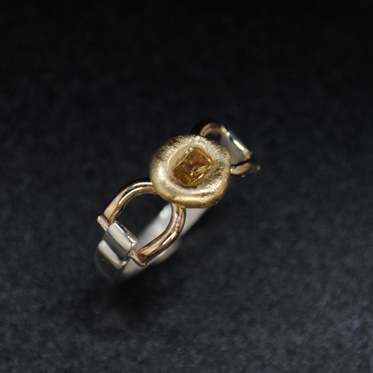 Gold and silver ring on a dark textured surface