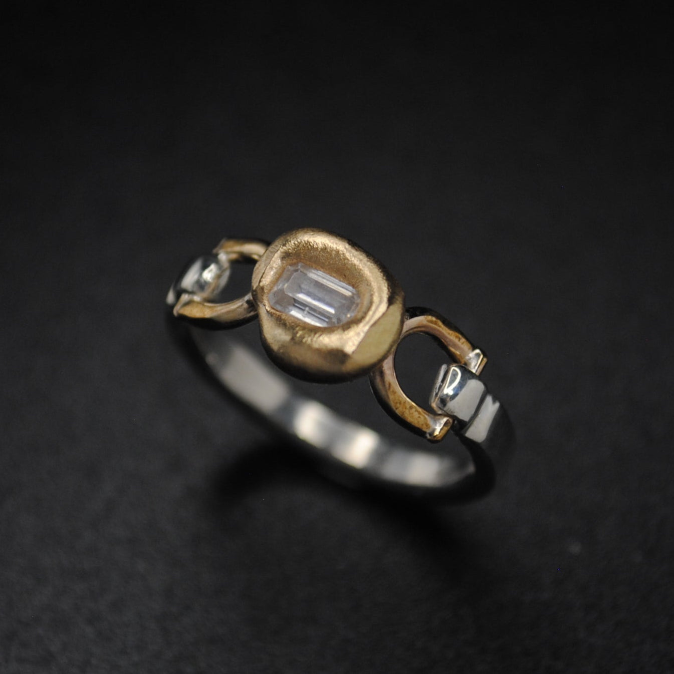 Gold ring with diamond on a dark textured background