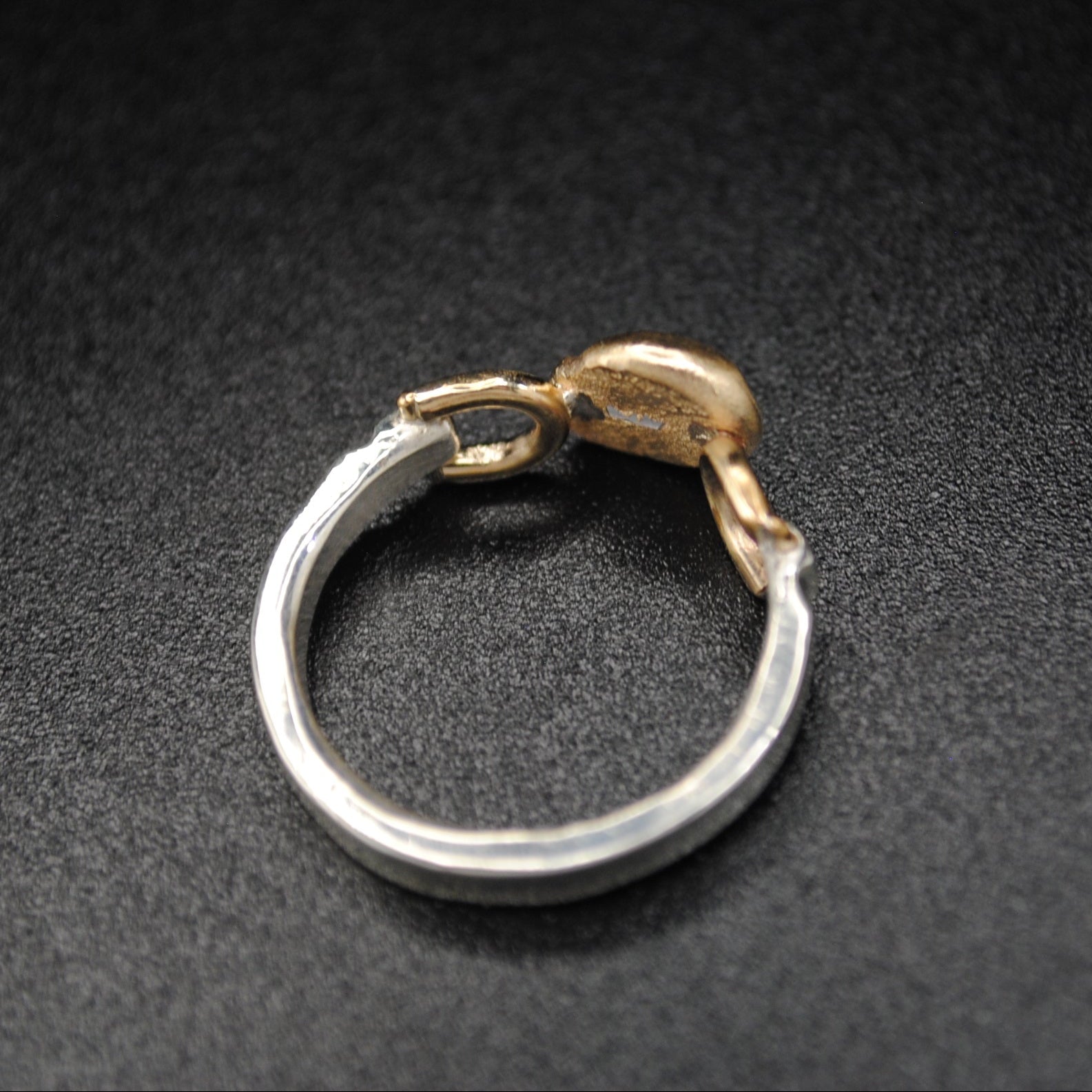 gold and silver ring on black background.